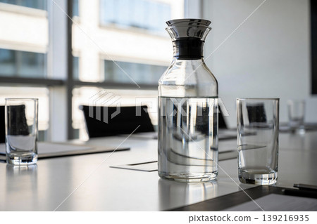 Modern glass carafe and tumblers on a conference table, ready for a meeting Modern glass carafe and tumblers on a conference table, ready for a meeting 139216935