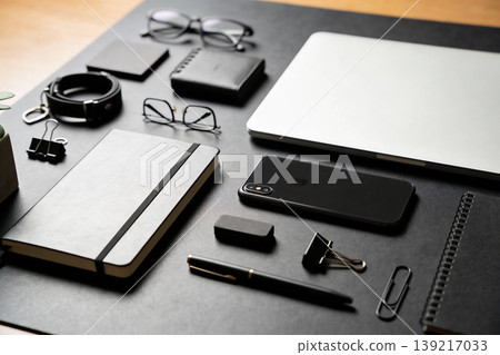 Modern minimalist desk setup with essential work and personal items arranged neatly 139217033
