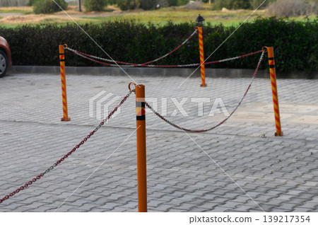 Colorful barriers create a playful contrast on a serene outdoor pathway surrounded by green Colorful barriers create a playful contrast on a serene outdoor pathway surrounded by green 139217354