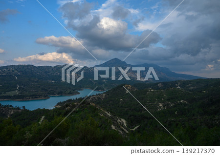 Breathtaking view of the tranquil lake and majestic mountains under a dramatic sky at dusk in a remote natural landscape Breathtaking view of the tranquil lake and majestic mountains under a dramatic sky at dusk in a remote natural landscape 139217370