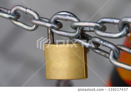Locked securely, ensuring safety with a sturdy padlock on a chain link, representing protection in an urban environment Locked securely, ensuring safety with a sturdy padlock on a chain link, representing protection in an urban environment 139217437