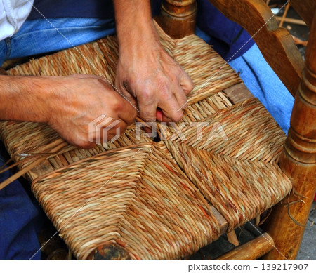 enea traditional spain reed chair handcraft man hands working 139217907