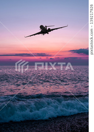 Corporate airplane take off over the sea against the backdrop of scenic sunrise sky 139217926