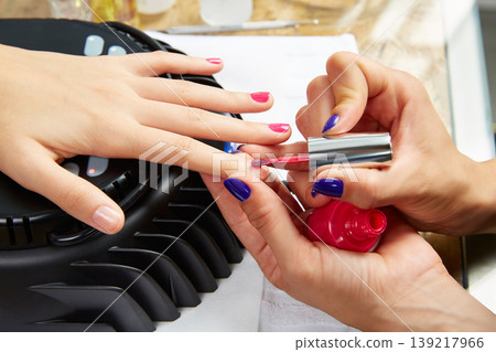 Nails painting with UV dry lamp in blue light Nails painting with UV dry lamp in blue light 139217966