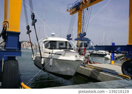 Dock crane elevating a fishing boat 139218129