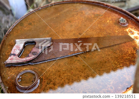 Rusted old saw tool over rusty background Rusted old saw tool over rusty background 139218551