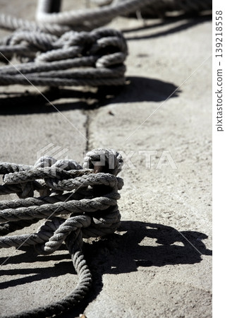 Boat bollard, ropes and knots in mediterranean harbor Boat bollard, ropes and knots in mediterranean harbor 139218558
