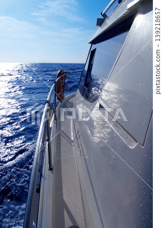 Boat side sailing in blue sea sun reflection Boat side sailing in blue sea sun reflection 139218657
