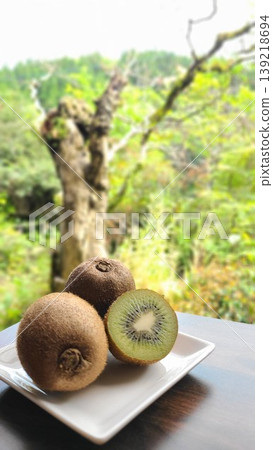 Cross-section and whole kiwi fruit on a white plate Cross-section and whole kiwi fruit on a white plate 139218694