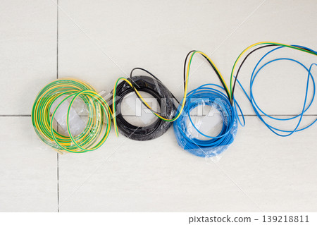 Electric cable coil in three colors black blue and earth Electric cable coil in three colors black blue and earth 139218811
