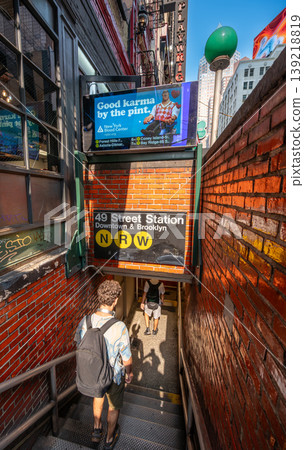 New york, usa august 16,2024. Commuters entering 49th street subway station in manhattan, sunlight and shadows on brick steps, urban life and movement in nyc 139218819