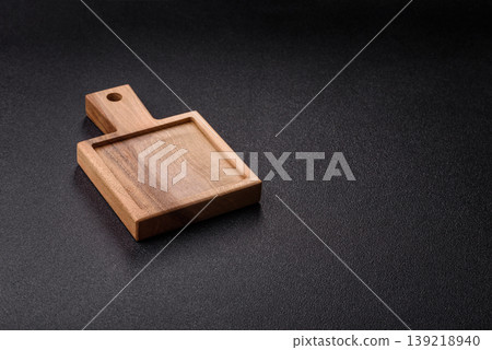 An empty wooden cutting board, kitchen utensils for food preparation. An empty cutting board An empty wooden cutting board, kitchen utensils for food preparation. An empty cutting board 139218940