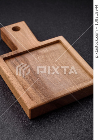 An empty wooden cutting board, kitchen utensils for food preparation. An empty cutting board An empty wooden cutting board, kitchen utensils for food preparation. An empty cutting board 139218944