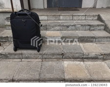 Black Suitcase Standing on Old Concrete Steps Black Suitcase Standing on Old Concrete Steps 139219043