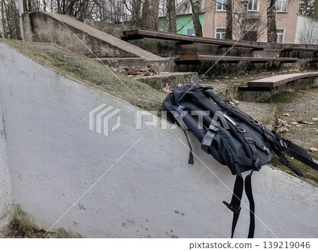 Modern black backpack on a concrete ledge Modern black backpack on a concrete ledge 139219046