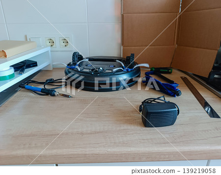 Robot vacuum cleaner open for repair on workbench 139219058