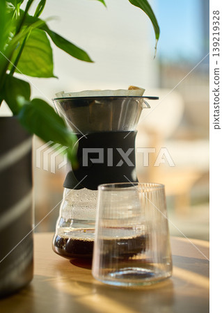 Fresh brewed coffee in dripper carafe with glass on table Fresh brewed coffee in dripper carafe with glass on table 139219328