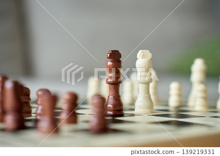 Black and white chess queens on chessboard 139219331