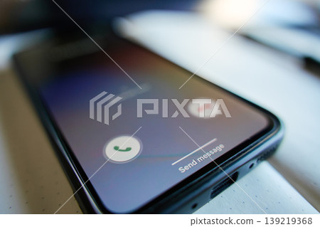 Smartphone with incoming call screen on desktop 139219368