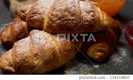 Baked croissants dusted with powdered sugar on a black board Baked croissants dusted with powdered sugar on a black board 139219607
