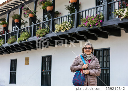 Happy senior woman concept. Senior travel concept. Senior woman at the beautiful colonial town of Villa de Leyva in Colombia Happy senior woman concept. Senior travel concept. Senior woman at the beautiful colonial town of Villa de Leyva in Colombia 139219842