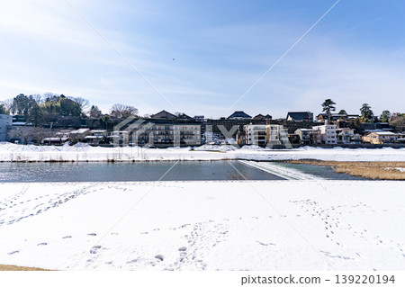 Snow-covered Kanazawa, the Sai River and the cityscape on the opposite bank. 139220194
