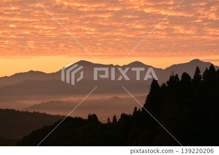 The Echigo Sanzan mountain range bathed in the morning glow of a sea of clouds. The Echigo Sanzan mountain range bathed in the morning glow of a sea of clouds. 139220206
