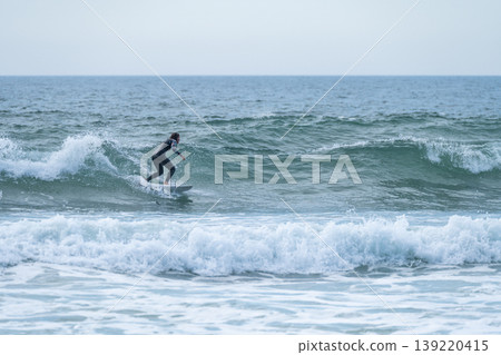 Surfer girl riding a wave Surfer girl riding a wave 139220415
