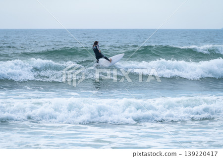 Surfer girl riding a wave 139220417