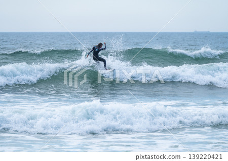 Surfer girl riding a wave Surfer girl riding a wave 139220421