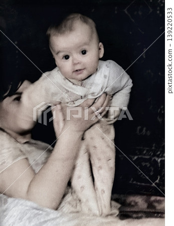 A vintage portrait of a little boy and his mother holding her son. Retro photo, 1968. A vintage portrait of a little boy and his mother holding her son. Retro photo, 1968. 139220533