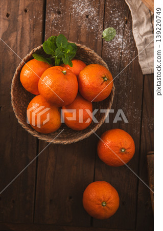 Fresh Tangerines in a Woven Basket on a Rustic Wooden Table Fresh Tangerines in a Woven Basket on a Rustic Wooden Table 139220749