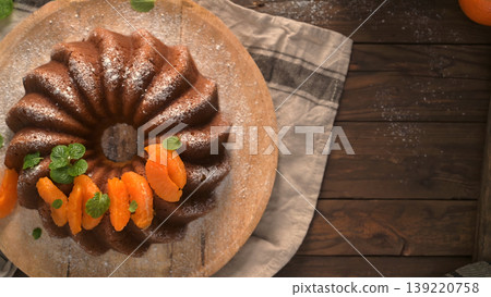 Bundt Cake with Orange Slices and Mint on Rustic Wooden Background 139220758