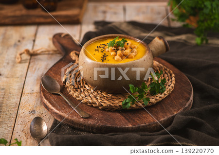Creamy Chickpea and Vegetable Soup Served in a Ceramic Bowl on a Rustic Wooden Table 139220770