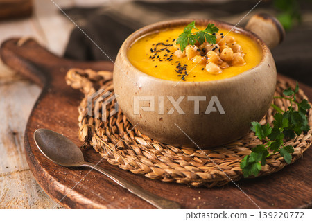 Creamy Pumpkin Soup Garnish with Chickpeas and Black Sesame Seeds in Ceramic Bowl 139220772