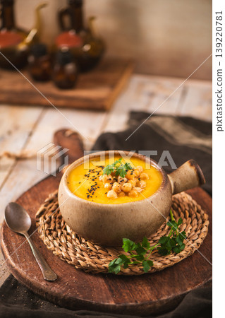 Creamy Chickpea and Pumpkin Soup in a Rustic Ceramic Bowl with Fresh Herbs Creamy Chickpea and Pumpkin Soup in a Rustic Ceramic Bowl with Fresh Herbs 139220781