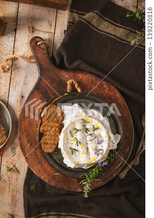 Baked Camembert Cheese with Rosemary and Garlic on a Rustic Wooden Board Baked Camembert Cheese with Rosemary and Garlic on a Rustic Wooden Board 139220816