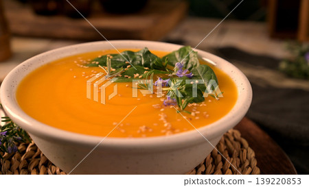 Creamy Pumpkin Soup Garnished with Fresh Spinach Herbs and Sesame Seeds 139220853