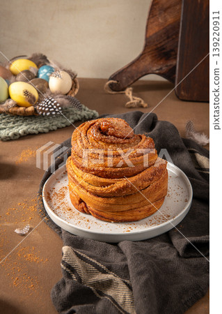 Layered Cinnamon Cruffin on a White Plate with Easter Eggs and Rustic Decor Layered Cinnamon Cruffin on a White Plate with Easter Eggs and Rustic Decor 139220911
