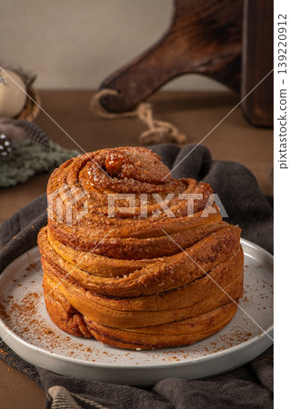 Golden Brown Cinnamon Cruffin with Sugar Crystals on a White Plate Golden Brown Cinnamon Cruffin with Sugar Crystals on a White Plate 139220912
