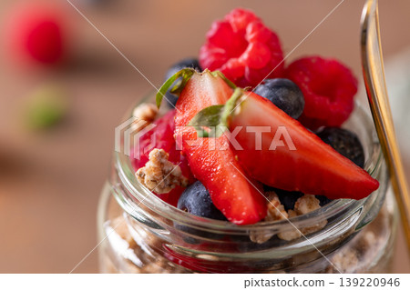 Healthy Breakfast Granola Parfait with Fresh Berries in a Glass Jar 139220946