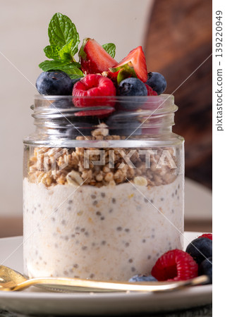 Layered Chia Seed Pudding and Granola Parfait with Fresh Berries in a Glass Jar 139220949