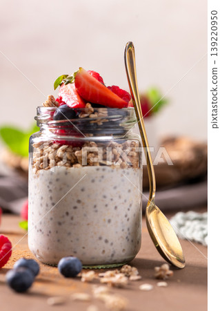Healthy Chia Pudding Parfait with Granola and Fresh Berries in a Glass Jar 139220950