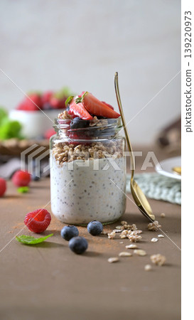 Healthy Chia Pudding and Yogurt Parfait with Mixed Berries and Granola in Glass Mason Jar 139220973