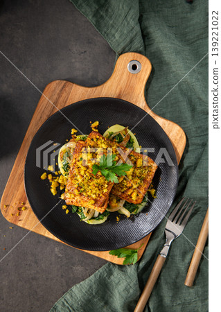 Top Down View of Roasted Tofu with Herb Crust and Sauteed Greens on a Black Plate Top Down View of Roasted Tofu with Herb Crust and Sauteed Greens on a Black Plate 139221022