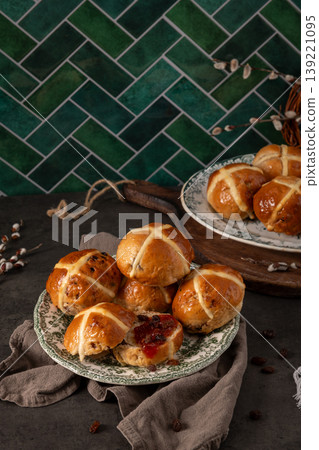 Festive Easter Hot Cross Buns Display with Green Herringbone Tile Background 139221095