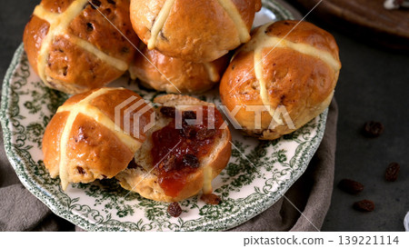 Freshly Baked Hot Cross Buns Served with Jam and Raisins on Vintage Plate 139221114