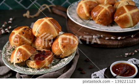 Freshly Baked Hot Cross Buns Served with Jam and Raisins on Vintage Plates 139221123