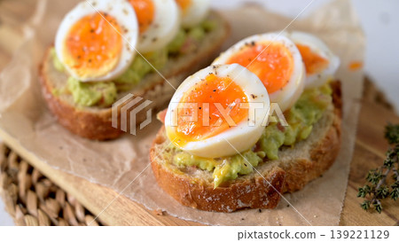 Avocado Toast Topped with Jammy Soft Boiled Eggs on Sourdough Bread Avocado Toast Topped with Jammy Soft Boiled Eggs on Sourdough Bread 139221129