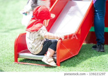 孩子們在幼兒園的戶外遊樂場玩耍,度過了快樂的一天。 孩子們在幼兒園的戶外遊樂場玩耍,度過了快樂的一天。 139221297